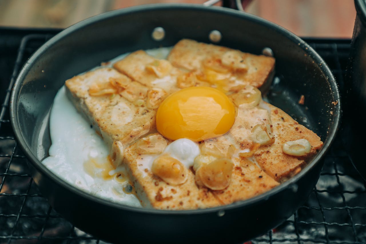 our-journey-03 High angle tasty homemade egg toasts on pan roasting on barbecue grid in backyard
